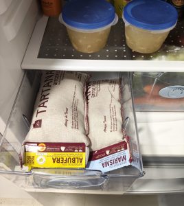 Un cajón de un frigorífico contiene dos paquetes de arroz tartana, para conservarlo correctamente en verano.
